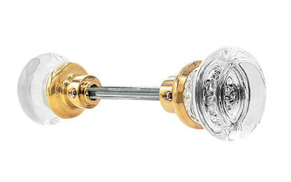 Pair of Classic Round Clear Glass Doorknobs with spindle. A high quality & genuine glass doorknob set with an attractive round design. The sparkling center point under glass amplifies reflected light to showcase beautiful facets. Solid brass base. Reproduction Glass Door Knobs. Traditional Round Glass Knobs. Unlacquered Brass (Will Patina Over Time). Non-Lacquered Brass.