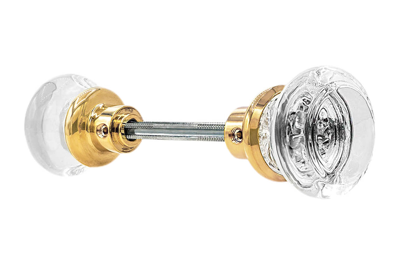 Pair of Classic Round Clear Glass Doorknobs with spindle. A high quality & genuine glass doorknob set with an attractive round design. The sparkling center point under glass amplifies reflected light to showcase beautiful facets. Solid brass base. Reproduction Glass Door Knobs. Traditional Round Glass Knobs. Lacquered Brass Finish.