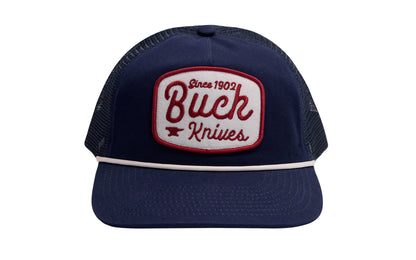 Buck Knives Five-panel snapback trucker hat in navy with white and red rounded Buck Knives felt patch and white rope. Low-profile with pre-curved bill. Navy twill and navy mesh. Snapback closure, adjustable fit. One size fits most. Buck Knives Ball Cap Hat.