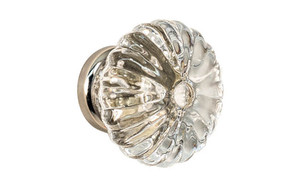 "Colonial Revival" Style Glass Cabinet Knob with Polished Nickel Base. Made of genuine glass. The ribbed glass is carefully set into a handsome brass material base with a threaded shank. Polished nickel finish on brass material base. Clear glass. Ribbed Glass Cabinet Knob. 1-3/4" Diameter Knob.