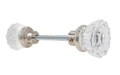 Pair of Classic Fluted Clear Glass Doorknobs with spindle. A high quality & genuine glass doorknob set with an attractive fluted design. The sparkling center point under glass amplifies reflected light to showcase beautiful facets. Solid brass base. Reproduction Glass Door Knobs. Traditional Fluted Glass Knobs. Polished Nickel Finish.